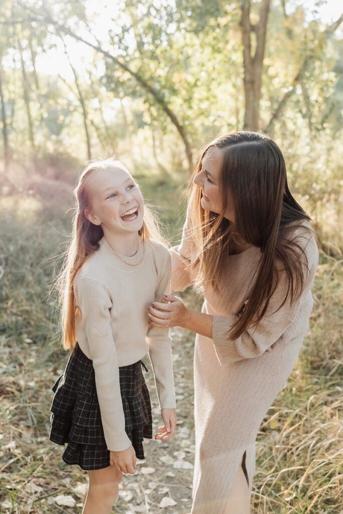 Young girl laughs joyfully as her mom expresses how much she loves her.